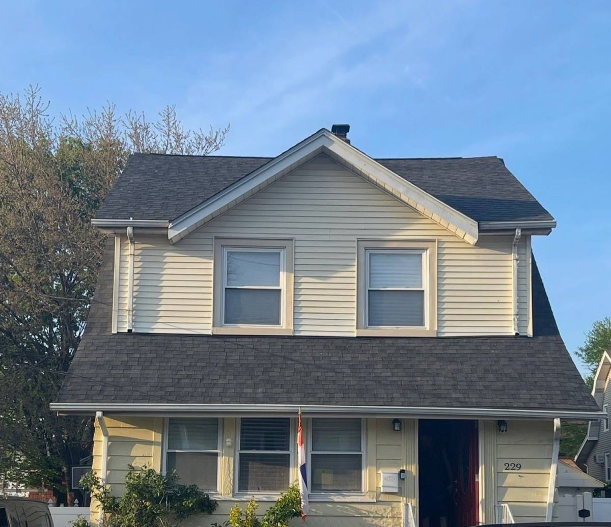 Same yellow home after replacement with the new roof