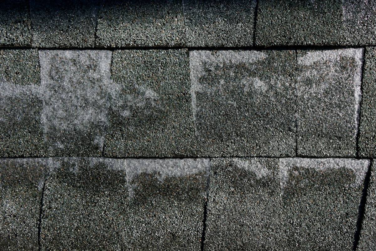 Weathered asphalt shingles showing damage and wear